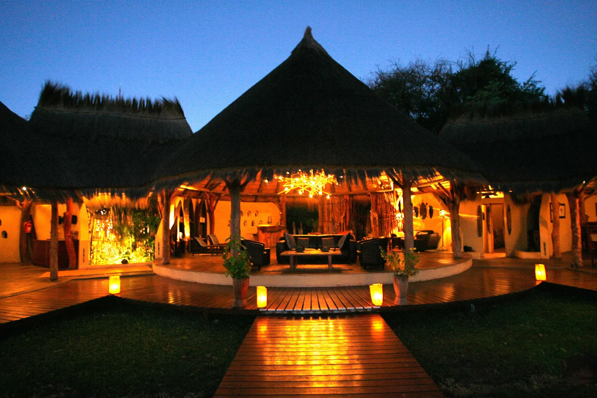 Camp Kwando Lodge at dusk with candlelit walkway